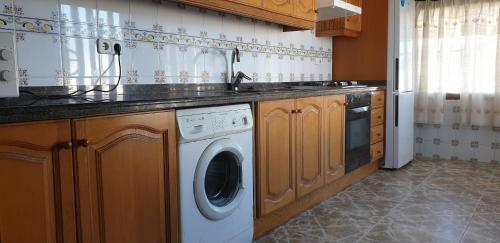 cocina con lavadora y fregadero en Habitaciones a un paso del Mar en Cullera en Cullera