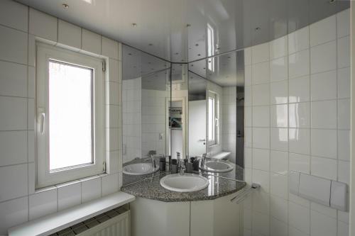 Baño blanco con 2 lavabos y ventana en Penthouse-Maisonette - City Center, Highspeed Internet, Garage, en Worms
