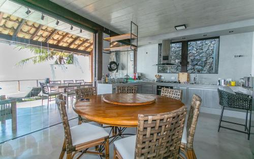 a kitchen and dining room with a wooden table and chairs at Refúgio da Arara in São Sebastião