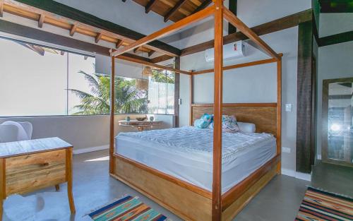 a bedroom with a canopy bed in a room at Refúgio da Arara in São Sebastião