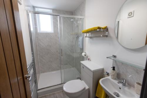 ein Bad mit einer Dusche, einem WC und einem Waschbecken in der Unterkunft Victoria Apartments in Skegness