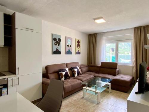 a living room with a couch and a glass table at Lovely Beach House with Own Beach & SUP for Guests in Donji Morinj
