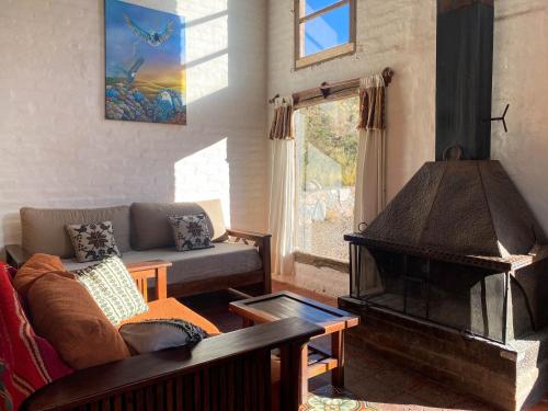 a living room with a couch and a fireplace at Las Margaritas in Potrerillos