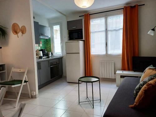 Il dispose d'une cuisine et d'un salon avec un réfrigérateur et une table. dans l'établissement Appartement Nice Libération, à Nice