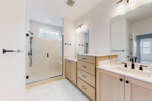 a bathroom with a shower and two sinks and a shower stall at Marlin Chase---30453 Madeira Ln in Ocean View