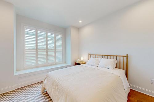 a white bedroom with a bed and a window at Marlin Chase---30453 Madeira Ln in Ocean View