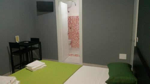 a room with a green rug and a shower at B&B Colors in Sellia Marina