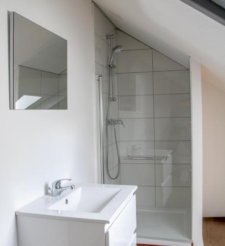 une salle de bain blanche avec un lavabo et une douche dans l'établissement NOUVEAU - Appartements Port Saint Goustan - Vue Rivière et Terrasses, à Auray