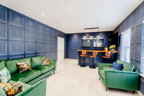a living room with blue walls and green couches at Newtown House in Newry
