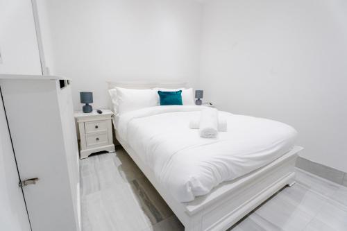a white bedroom with a white bed and a mirror at Newtown House in Newry