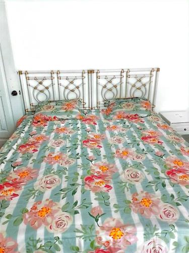 Una cama con colcha floral. en Bchome hostal en Boca Chica