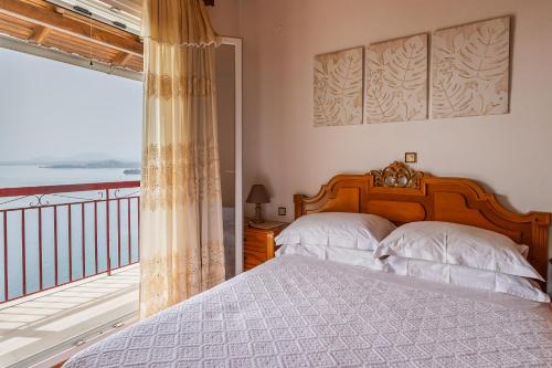 a bedroom with a bed and a balcony at Rena's house Corfu in Ágios Márkos