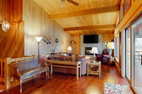 a living room with a leather couch and a fireplace at Lakefront Haven in Lake Tomahawk