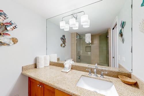 une salle de bain avec un lavabo et un miroir dans l'établissement Kahana Reef 413, à Kahana
