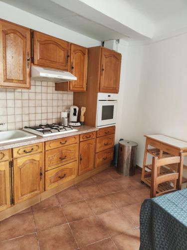 une cuisine avec des armoires en bois et un four à plaques de cuisson dans l'établissement Apt capitale du Luberon appartement 3 chambres 4 lits, à Apt