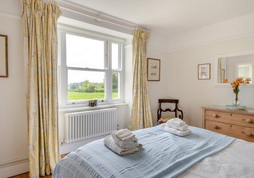 a bedroom with a bed with two towels on it at Lodge Farm Cottage in Sudbourne