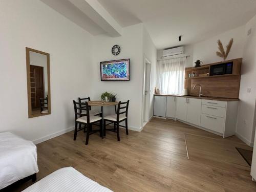 a kitchen with a table and chairs in a room at STUDIO APARTMANI IZVOR in Blagaj
