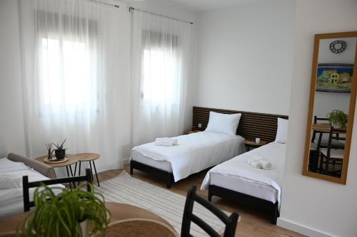 a bedroom with two beds and a table and a mirror at STUDIO APARTMANI IZVOR in Blagaj