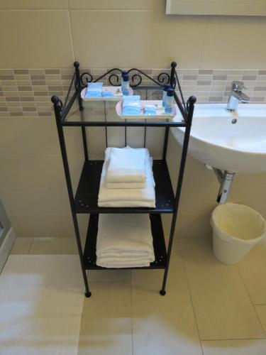 a towel rack next to a sink in a bathroom at Artisti Rooms in Ravenna