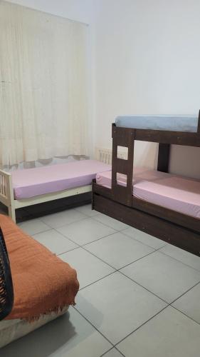 two bunk beds in a room with a tile floor at Condomínio Resort na cidade das águas sulfurosas in Poços de Caldas