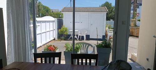 Elle offre une vue sur une terrasse avec une table et des chaises. dans l'établissement maison l'été à la plage, à Larmor-Plage