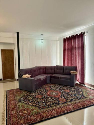 a living room with a brown couch and a rug at La Finca - Santa Cruz - Chile in Santa Cruz