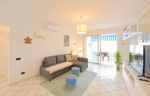 a living room with a couch and a tv at Re del MARE - 3 BR Apt - Lounge con vista da SOGNO in Porto Recanati