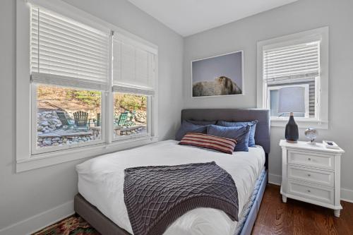 a bedroom with a bed and two windows at Wild Horse Run in New Buffalo