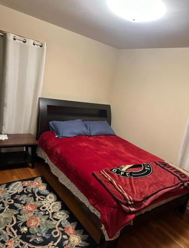 a bedroom with a bed with a red blanket at Connecticut Lake House in Bridgeport