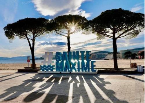 a bench with the words smileamine sitting on a beach at Maison Golfe de Saint Tropez in Sainte-Maxime