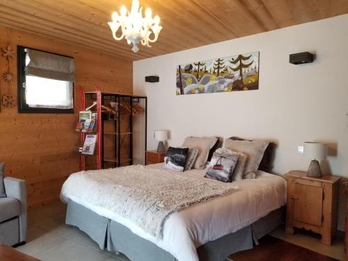 a bedroom with a bed and a chandelier at Chalet Walser à VALLORCINE 13 kms CHAMONIX France in Vallorcine