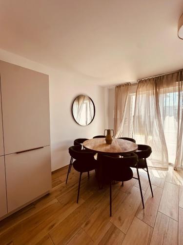 une salle à manger avec une table et un miroir dans l'établissement Maison Golfe de Saint Tropez, à Sainte-Maxime