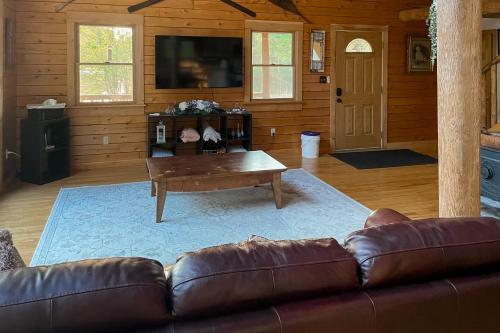 a living room with a leather couch and a coffee table at Charming Hideaway in Scarborough