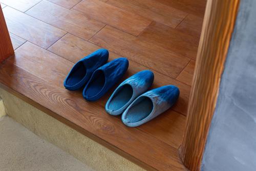 a pair of blue shoes sitting on a wooden table at 藍宿ル1185 in Noda