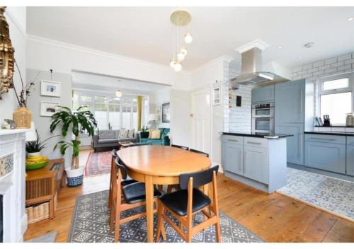 Il comprend une cuisine et un salon avec une table en bois. dans l'établissement lovely 2BR house in Orpington, à Orpington