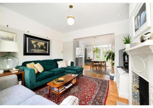 een woonkamer met een groene bank en een tafel bij lovely 2BR house in Orpington in Orpington