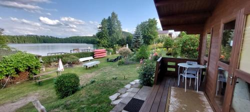 a balcony of a house with a view of a lake at Lemanka Domek Letniskowy in Gowidlino