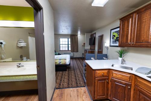ein Badezimmer mit einem Waschbecken und ein Badezimmer mit einem Bett in der Unterkunft Extended Stay Airport in Green Bay
