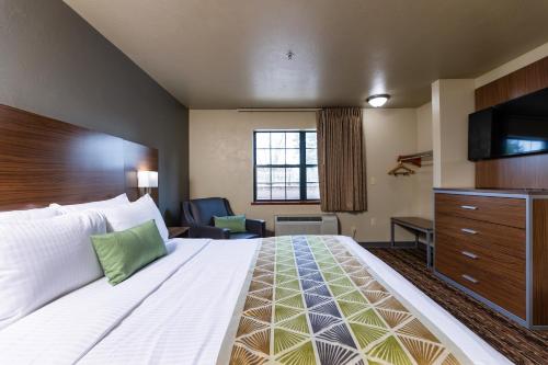 a hotel room with a large bed and a television at Extended Stay Airport in Green Bay