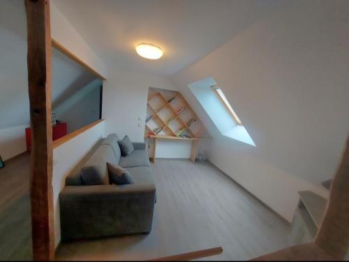 a living room with a couch and a staircase at Gîte de La Garrigue in Brandonnet
