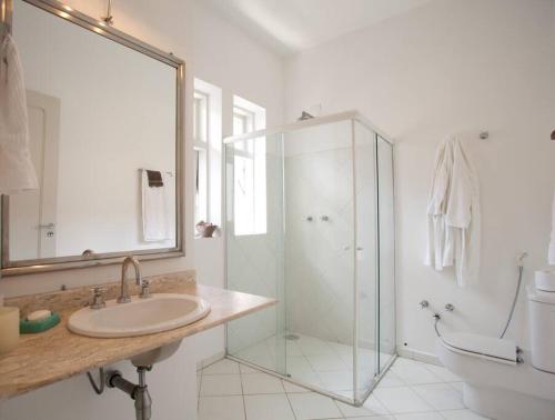 W łazience znajduje się szklana kabina prysznicowa i umywalka. w obiekcie Charmosa casa 4 suítes no Jd Europa w São Paulo