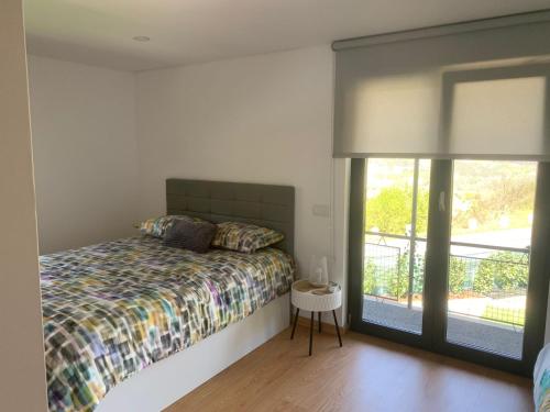 a bedroom with a bed and a large window at Casa do Miradouro Mondim de Basto in Mondim de Basto