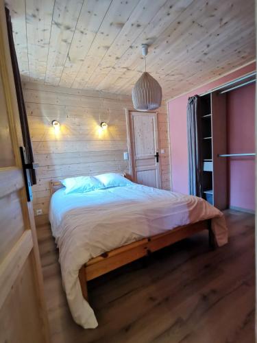 une chambre avec un lit dans une pièce en bois dans l'établissement Appartement en centre ville Au pied de l'Izoard, à Briançon