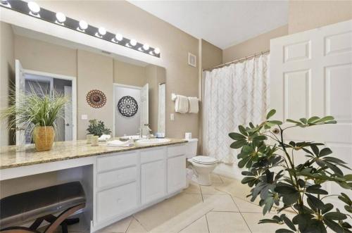 a bathroom with a sink and a toilet and a mirror at Disney Holiday Palace in Orlando