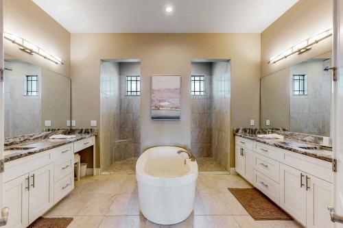 ein großes Bad mit 3 Waschbecken und einer Badewanne in der Unterkunft The Pink Flamingo Sanctuary in Cape Coral