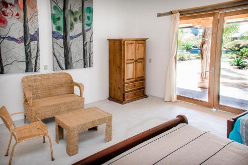 a bedroom with a bed and a chair and a table at El MURO MAJAHUA RETREAT CENTER in La Majahua