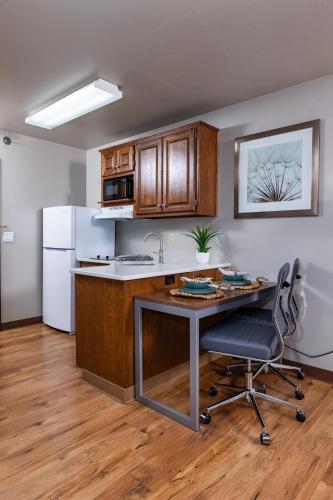 a kitchen with a desk and a white refrigerator at Extended Stay Airport in Green Bay