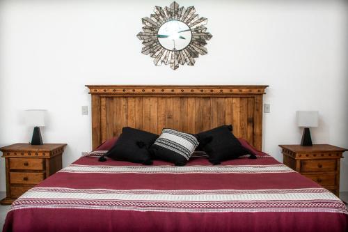 a bedroom with a large bed with a clock on the wall at El MURO MAJAHUA RETREAT CENTER in La Majahua