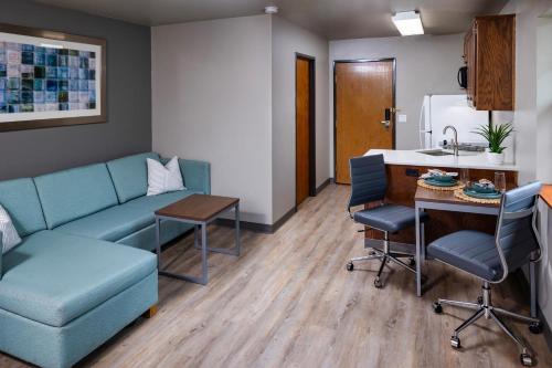a living room with a couch and a table and a kitchen at Extended Stay Airport in Green Bay