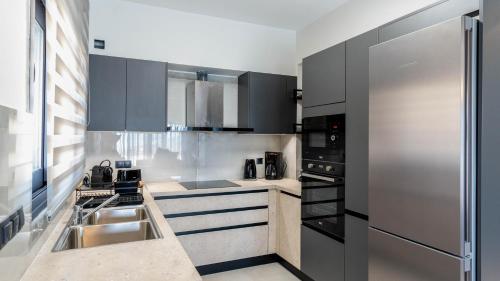 a kitchen with a sink and a refrigerator at Adaman Villas in Meganisi